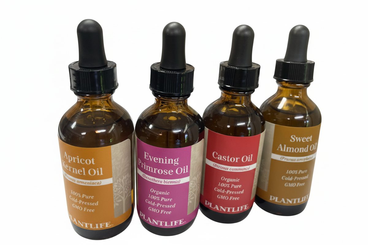 Four amber carrier oil bottles with their background removed